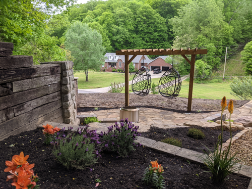stonework hangout area with garden and chairs