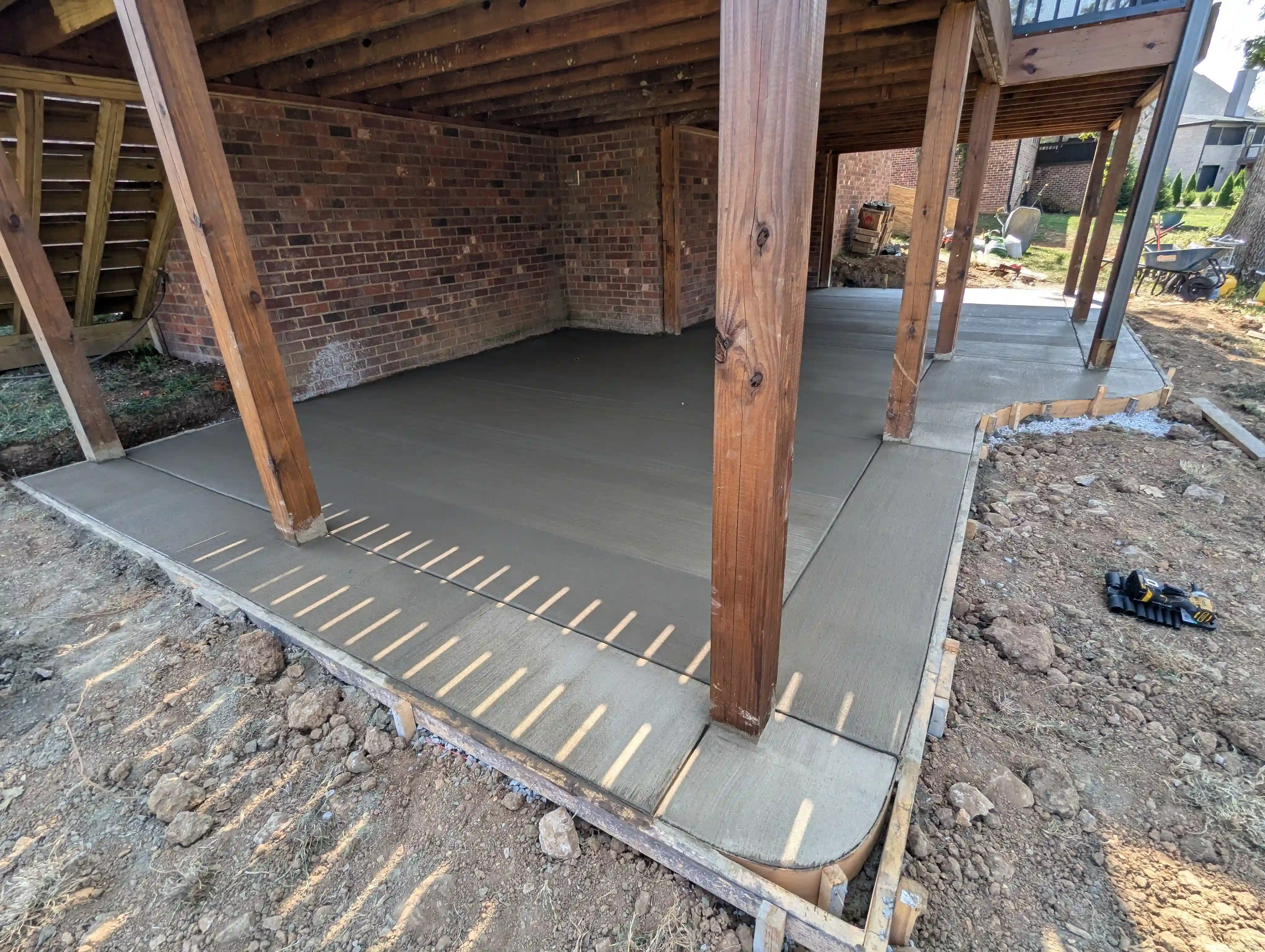 concrete patio underneath a large wooden structure
