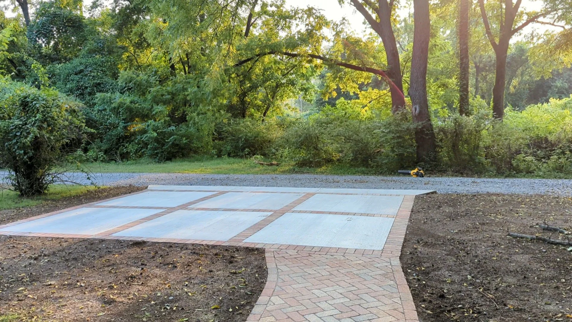 6 large concrete pads lined with small red bricks with a brick walkway