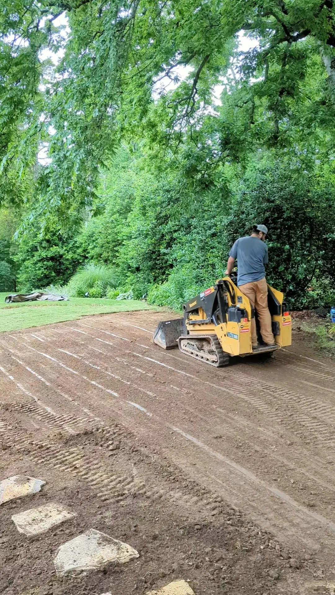 man on mini bobcat sloping a yard