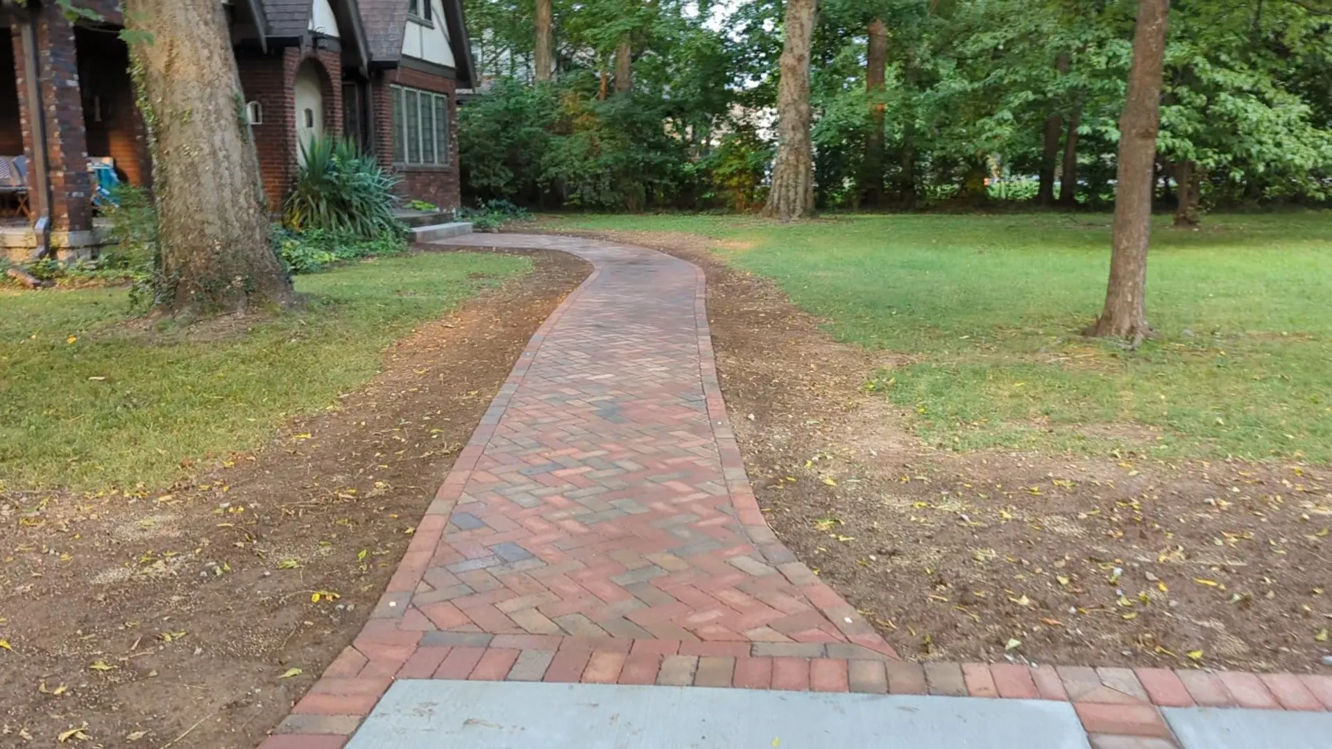 small red brick paver patio leading to the front porcv