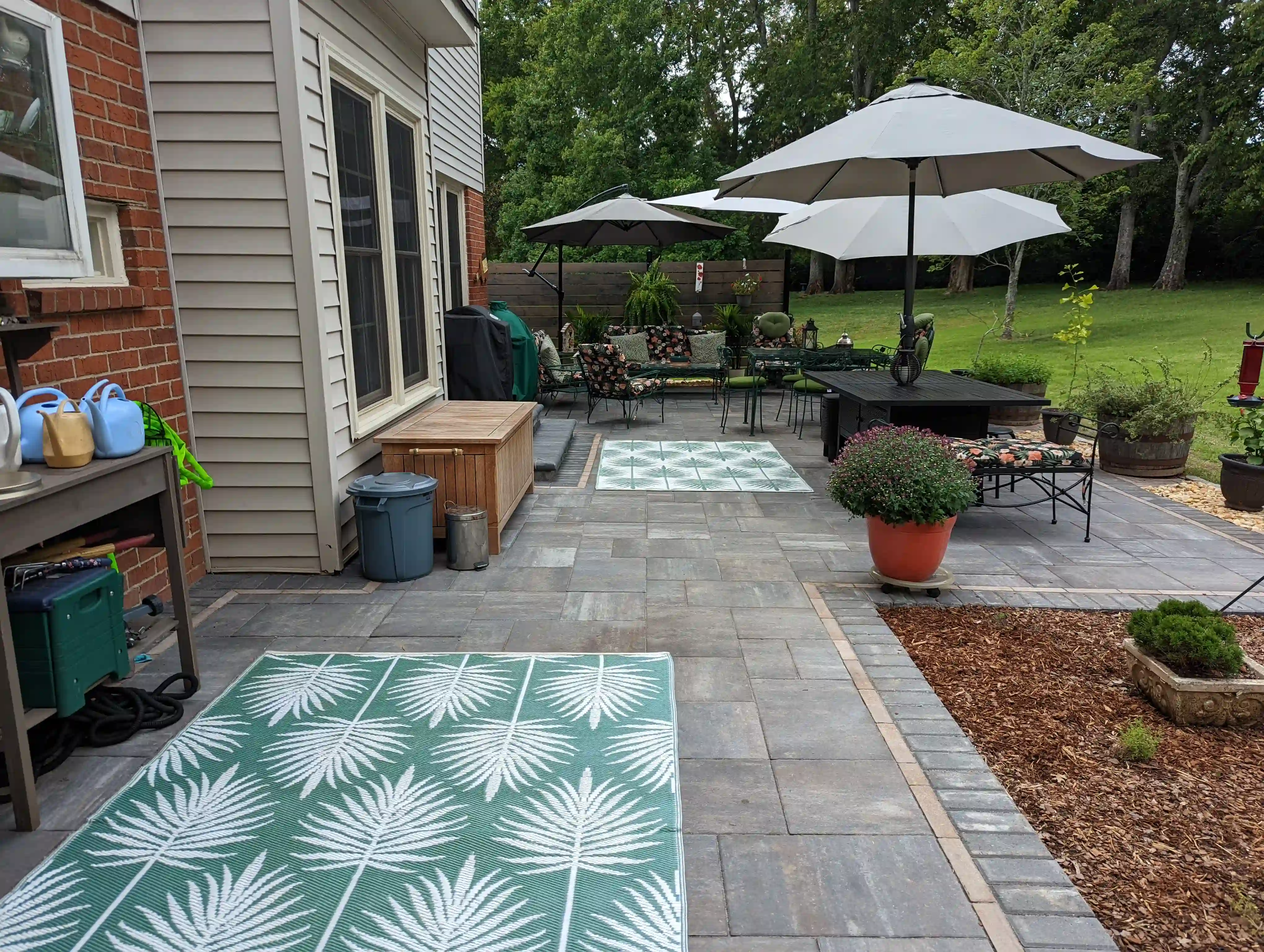 paver patio in the backyard with multiple sun shades, tables and chairs
