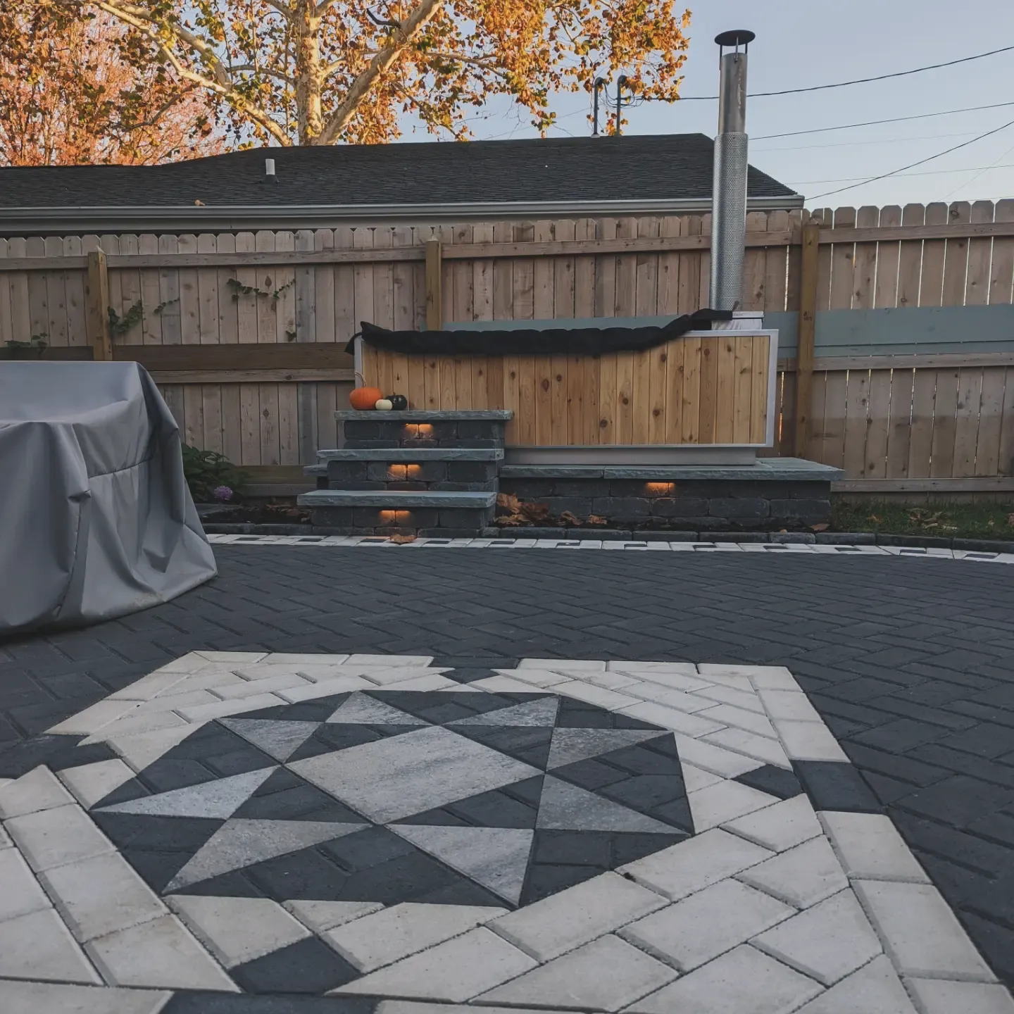 white and dark grey paver patio with a cool design leading to a hot tub