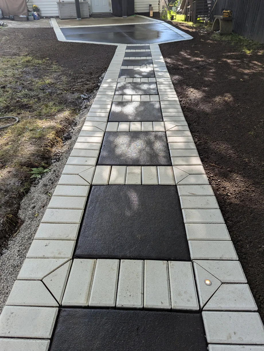 walkway with large black paver surrounded by smaller white pavers