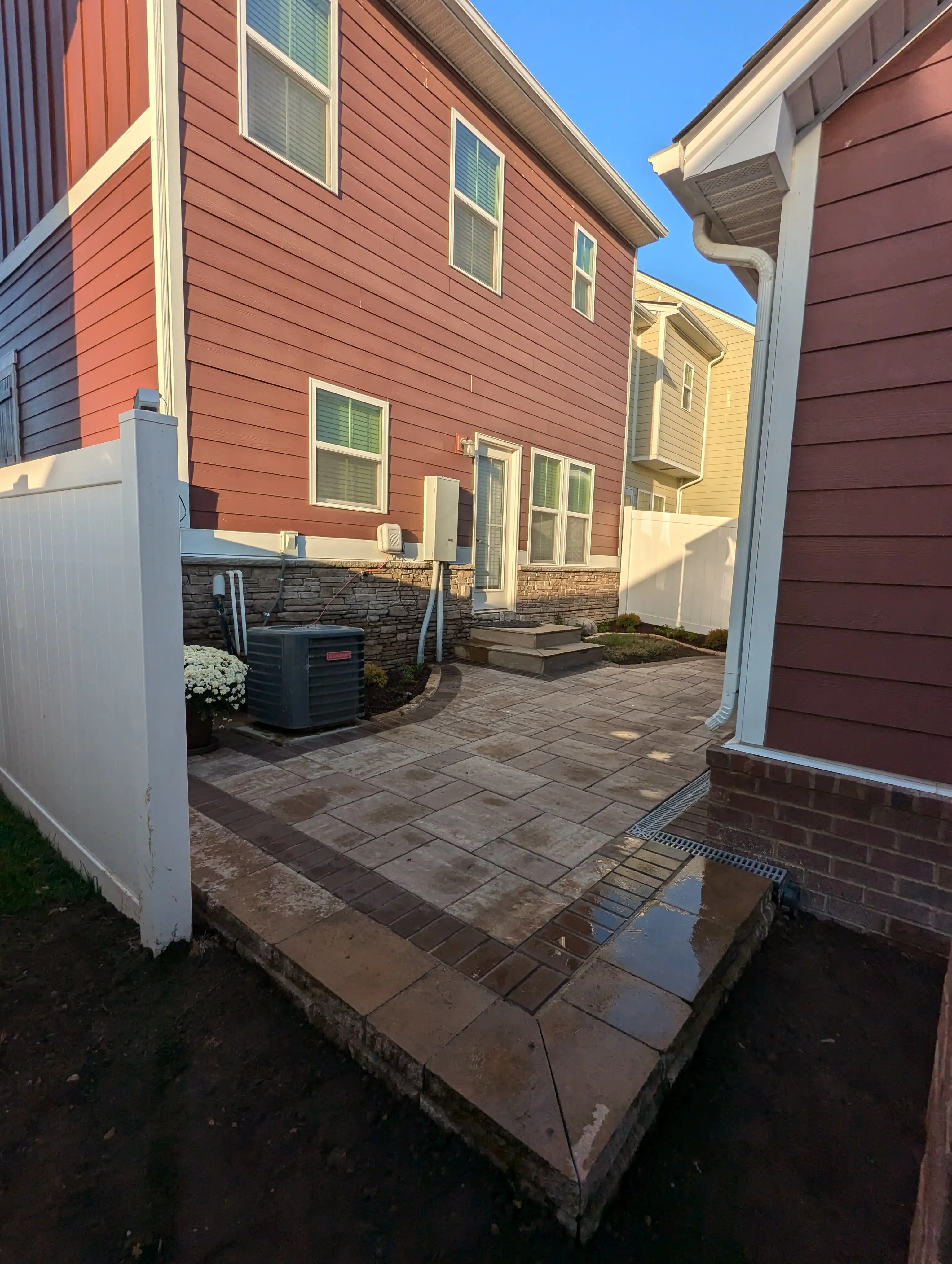patio area in the back of a house made from large and small paver stones