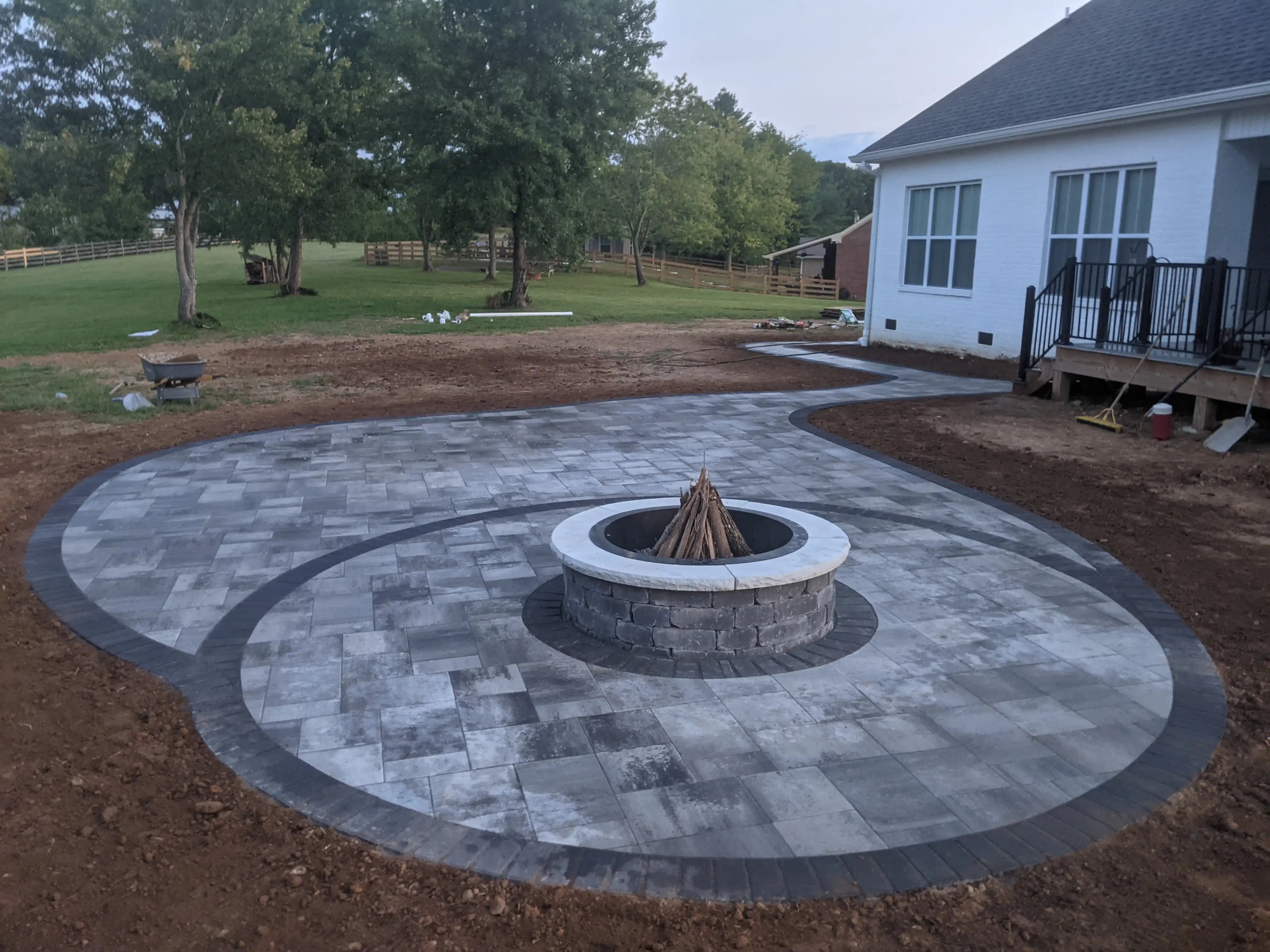 circular paver patio with a firepit in the middle