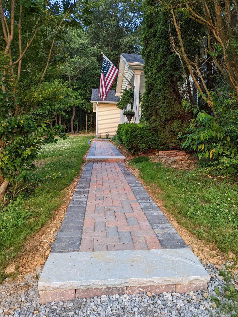 paver walkway to the front door of a house with an american flag
