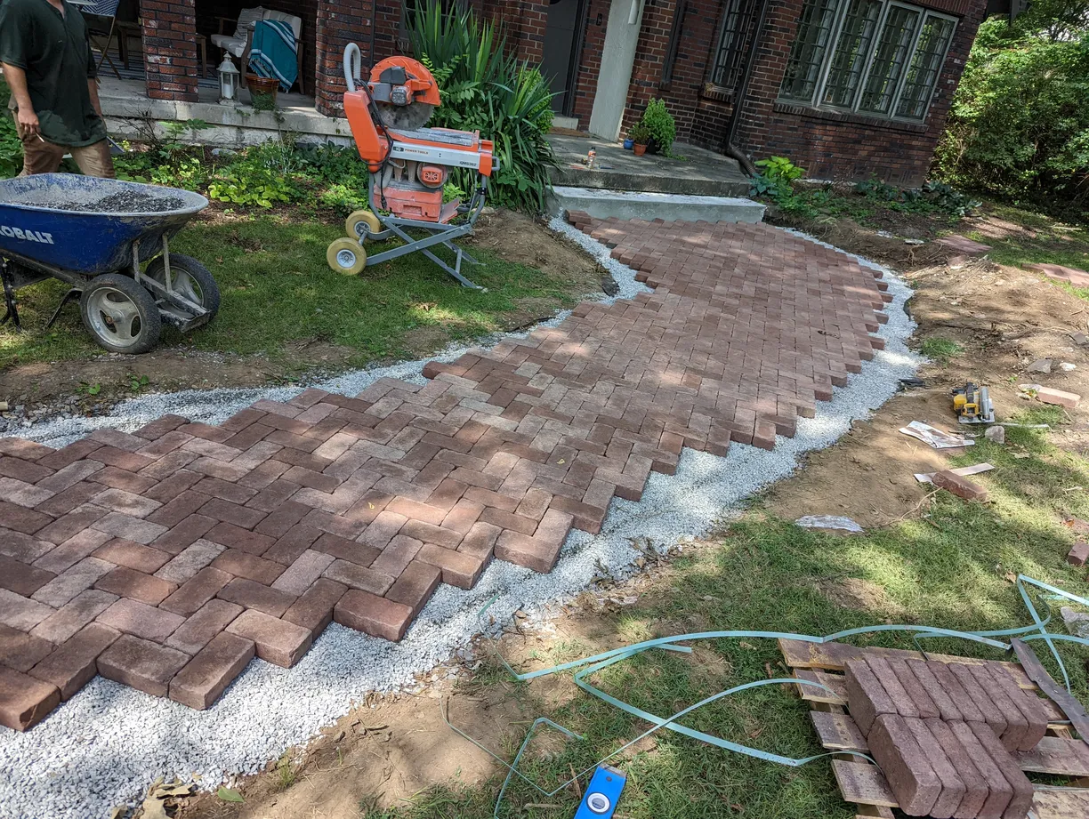 small red brick paver walkway being cut and laid
