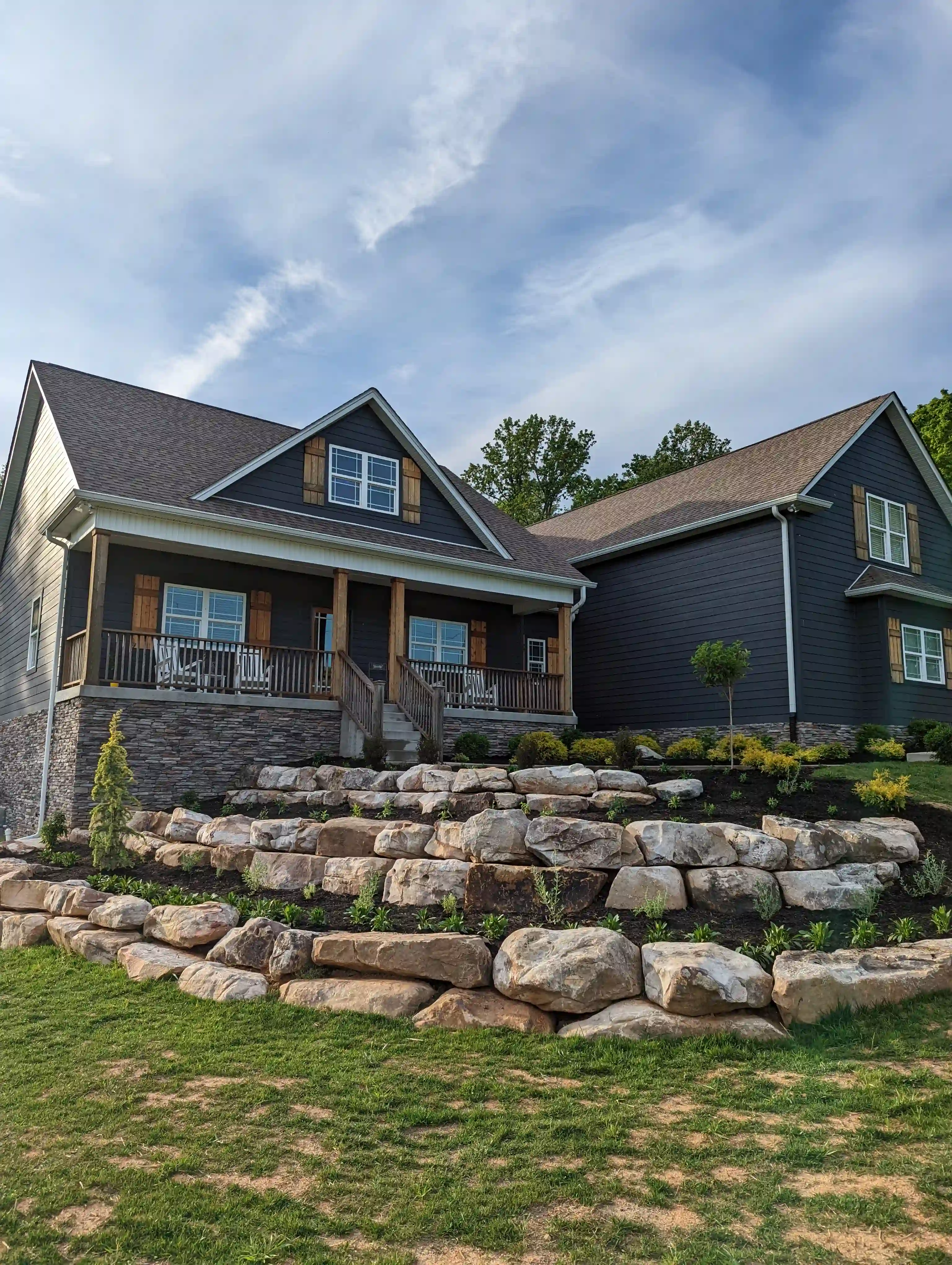 three layered large stone retaining wall with garden beds in between each wall