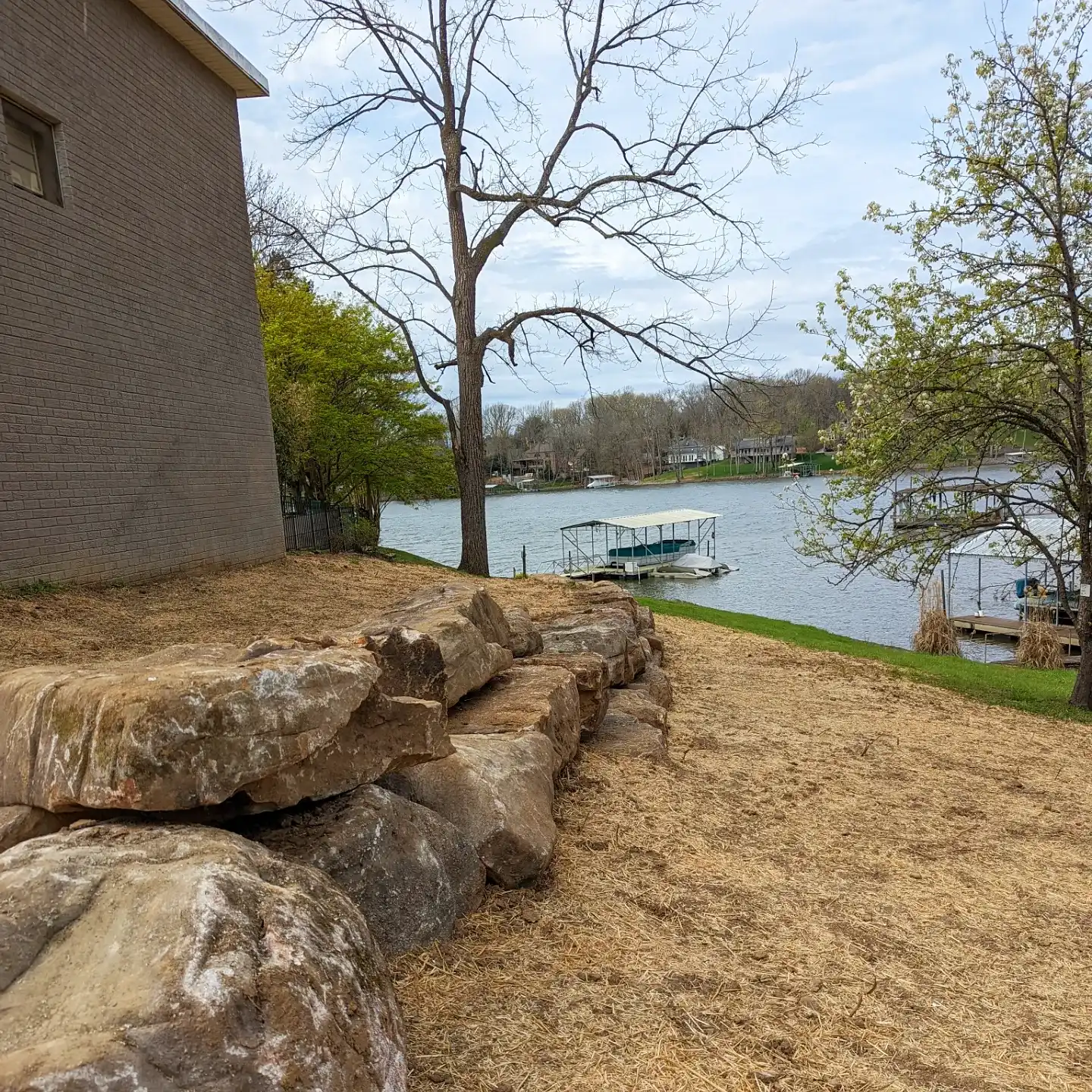 large natural stone retaining wall overlooking a lake
