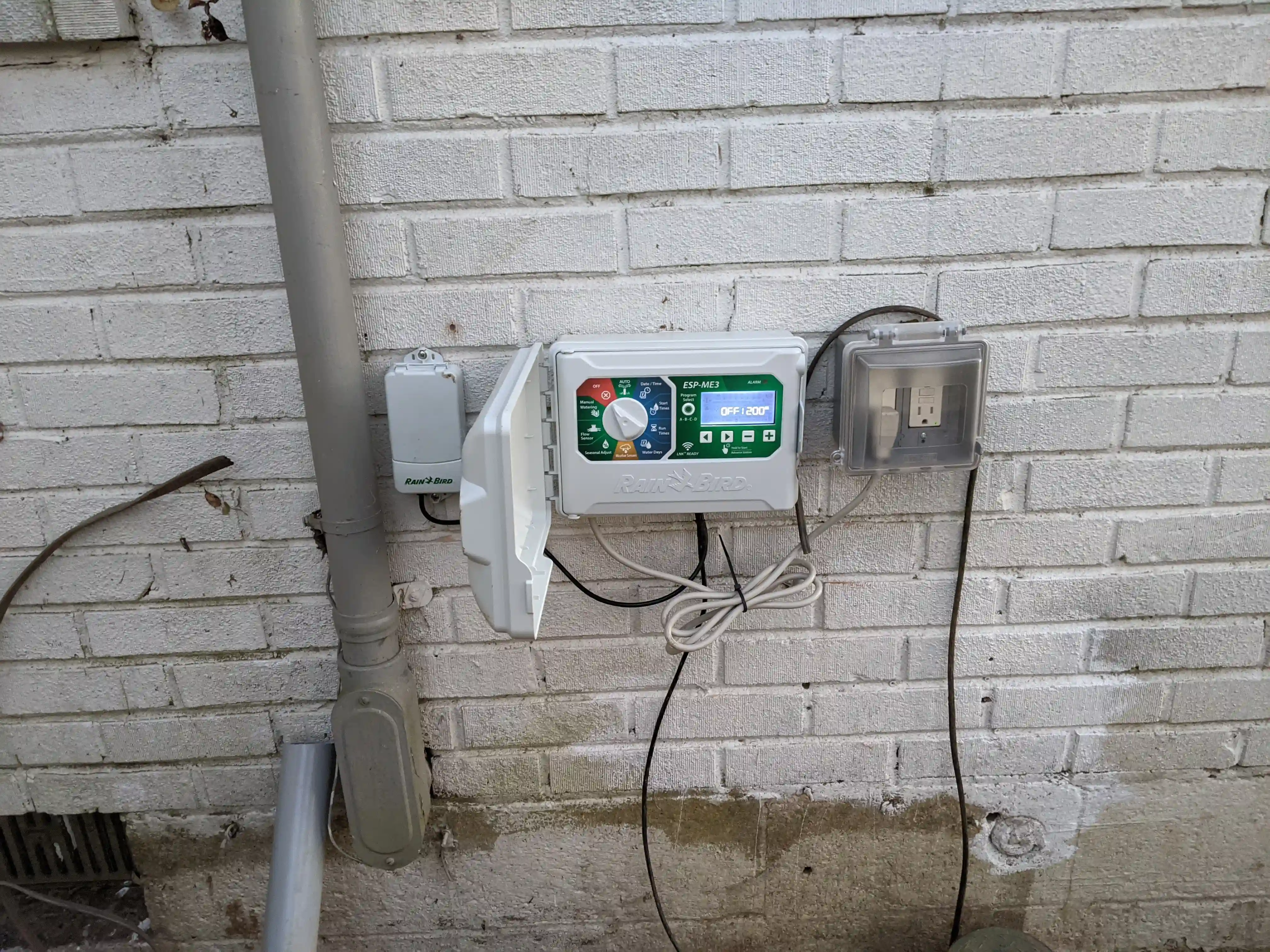 sprinkler control system on the side of a house