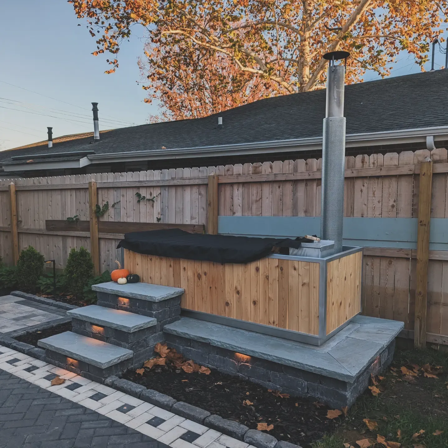 black bricked area with steps leading to a hot tub